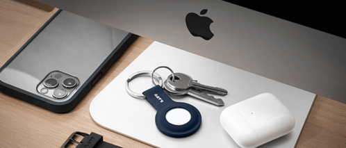 LAUT AirTag Anhänger in der Farbe Navi neben einem iPhone, Mac und AirPods